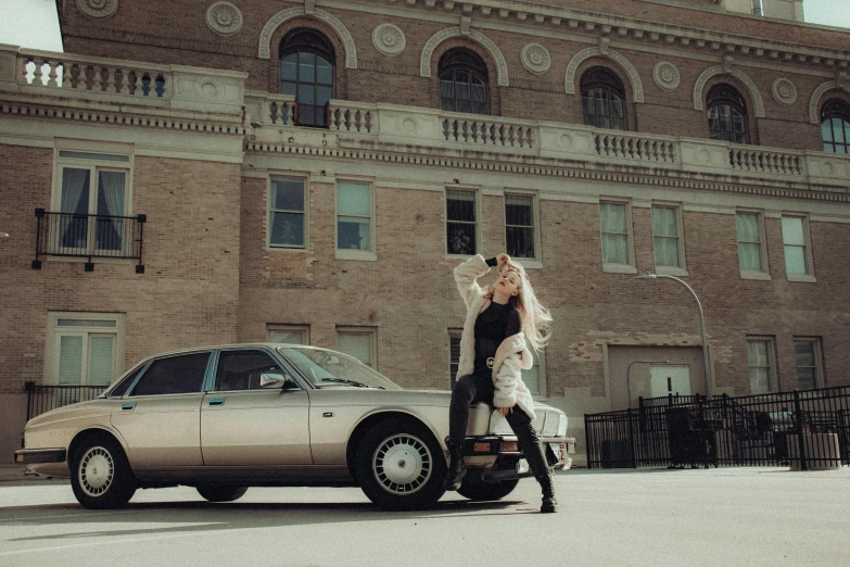 a beautiful blond haired woman standing next to a parked car