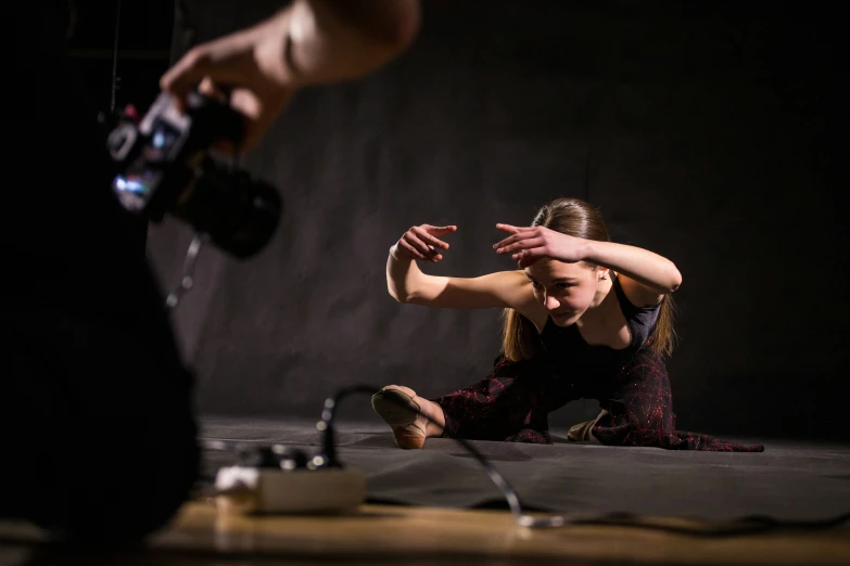 a young woman is sitting on the ground near some microphones