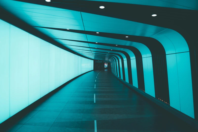 an empty walkway with light shining down in the dark