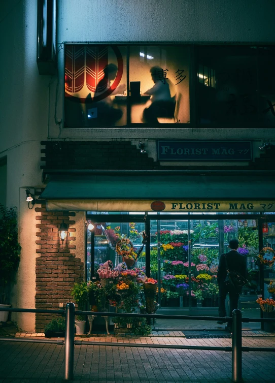 a man stands in front of a flower store at night