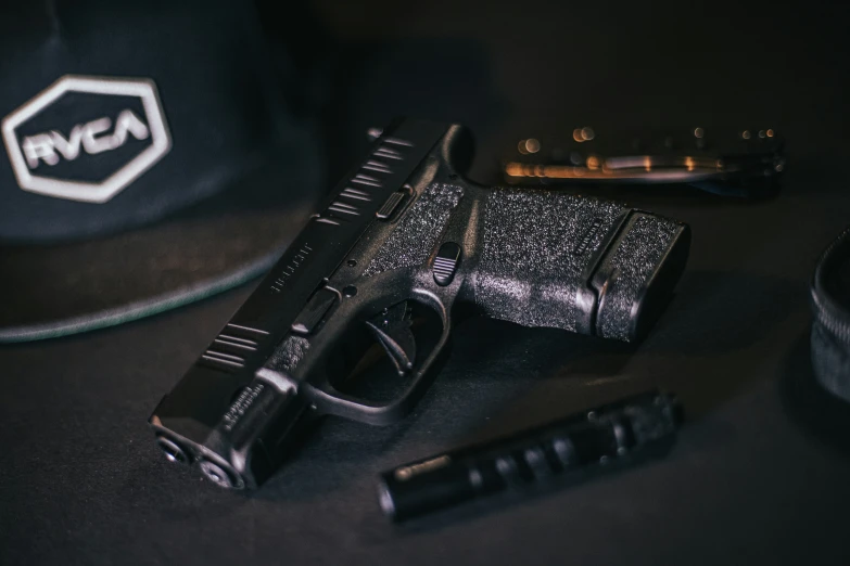 a gun, knife, and cap sitting on a table