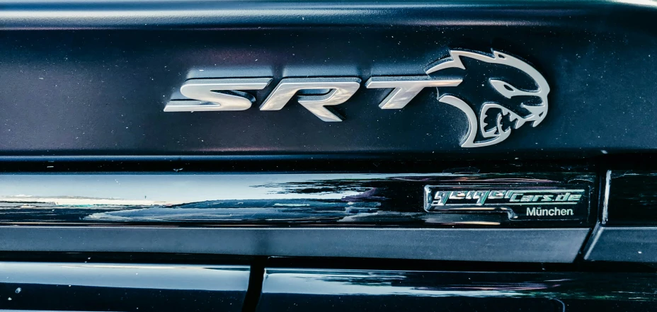 the front of a black pickup truck with an srt emblem