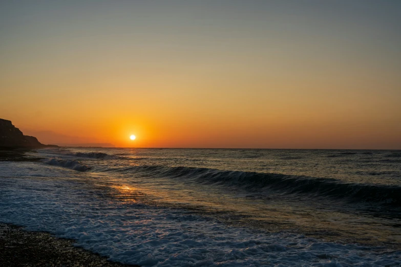 there is a bright sun setting over the ocean