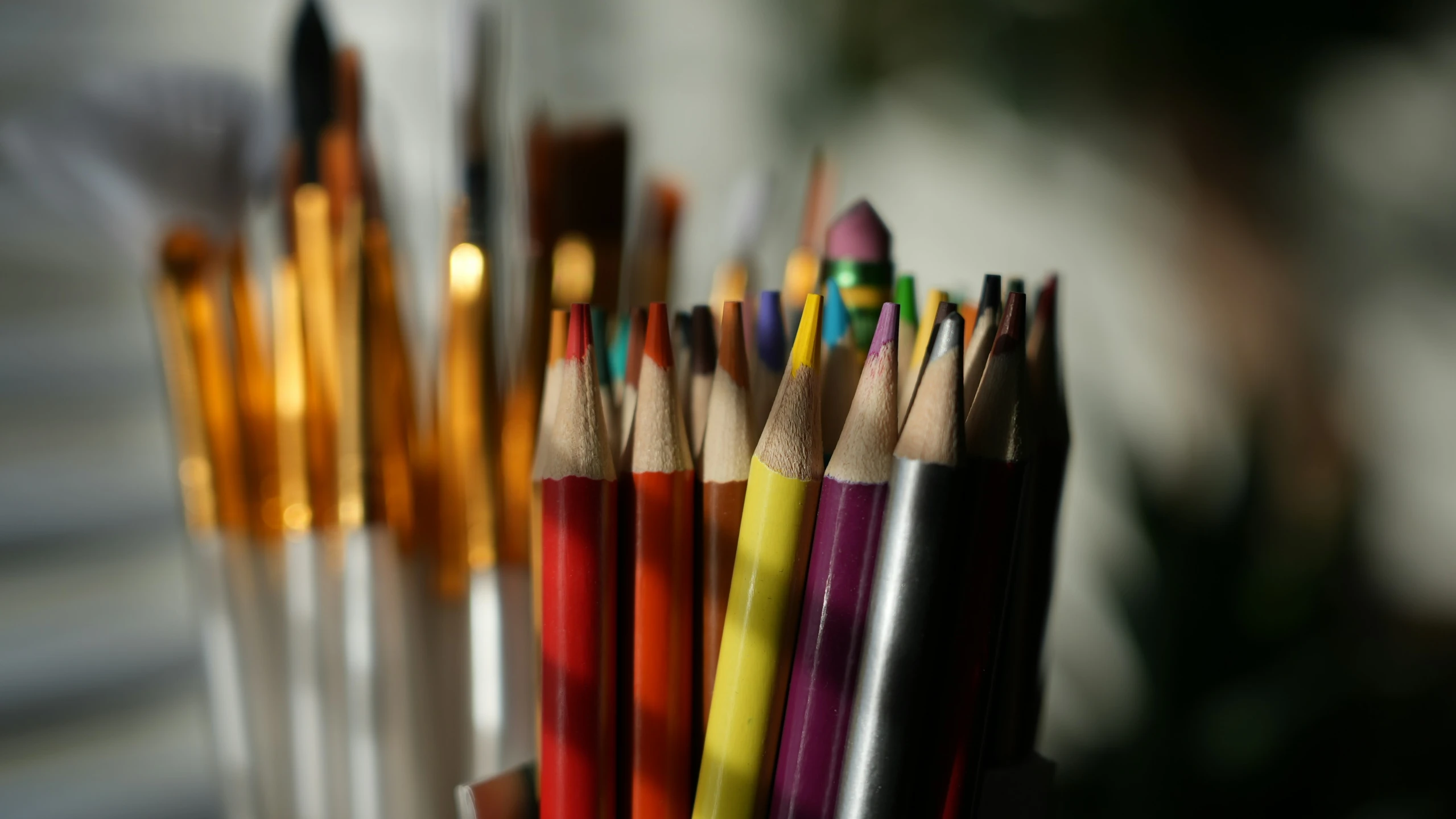 multicolored pencils with pens sticking out of the end