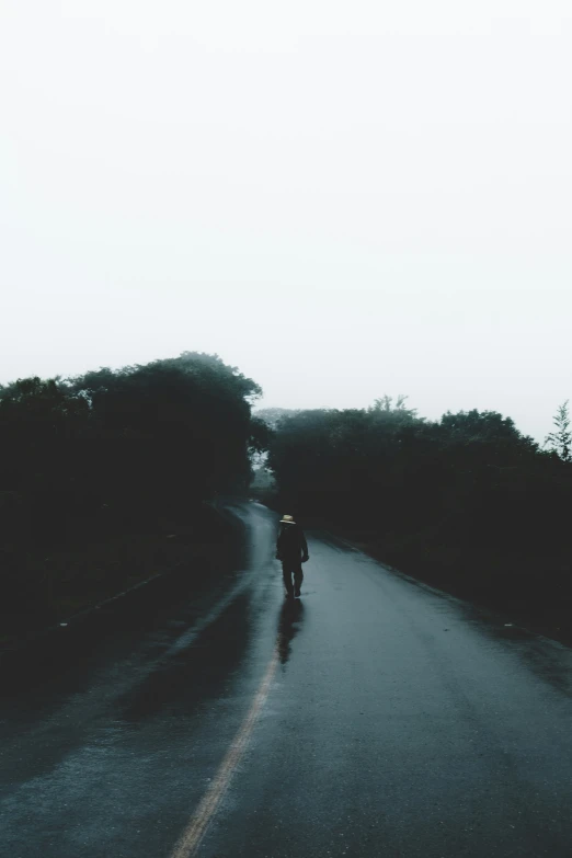 a person is walking down a wet road