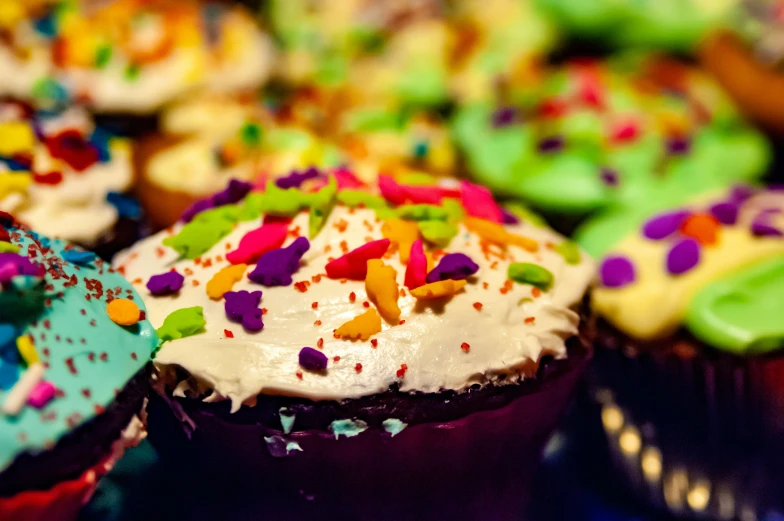 many cupcakes are decorated in multi - colored sprinkles