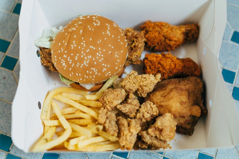 an open box contains fried chicken and french fries
