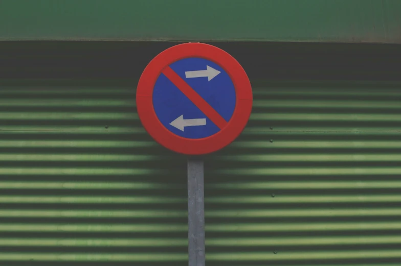 a red and blue sign next to green wall