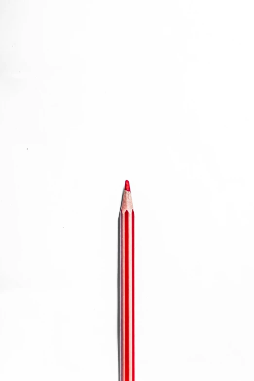 a red pencil sits on a white surface