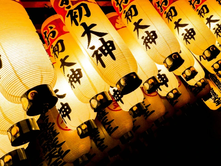 many lanterns that have been lit up with asian writing on them