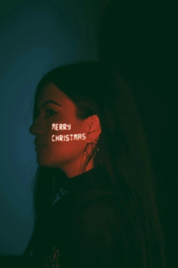 a woman wearing the words merry christmas spelled in red