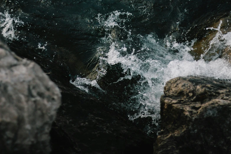 a person climbing up a cliff above the ocean