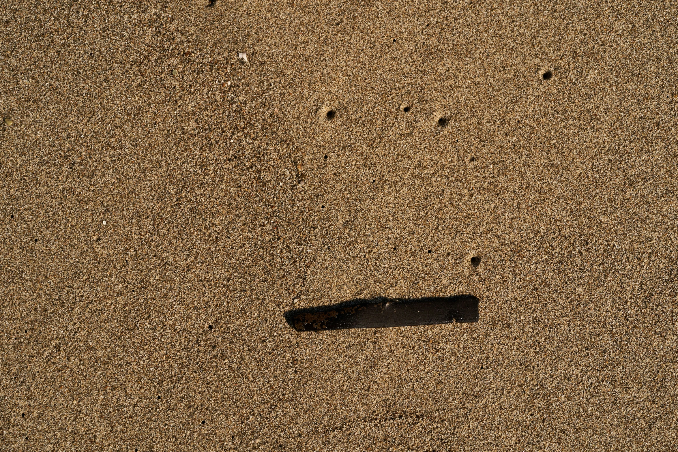 a shadow and a rock in the sand