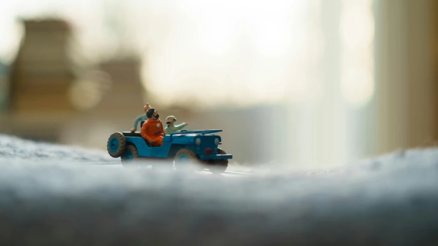 a toy car driving down the road, in between buildings