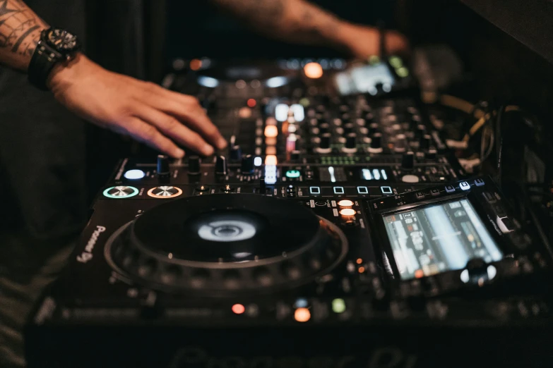 a dj mixing up music in front of a large set of equipment