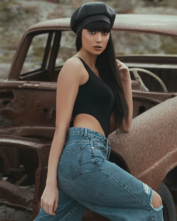 a woman is posing by a rusted truck