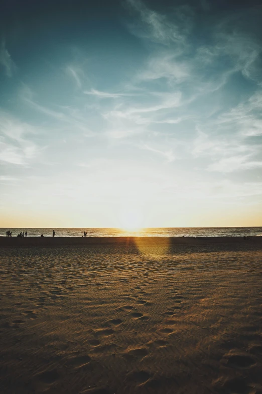 a sunset on the beach with sand and water