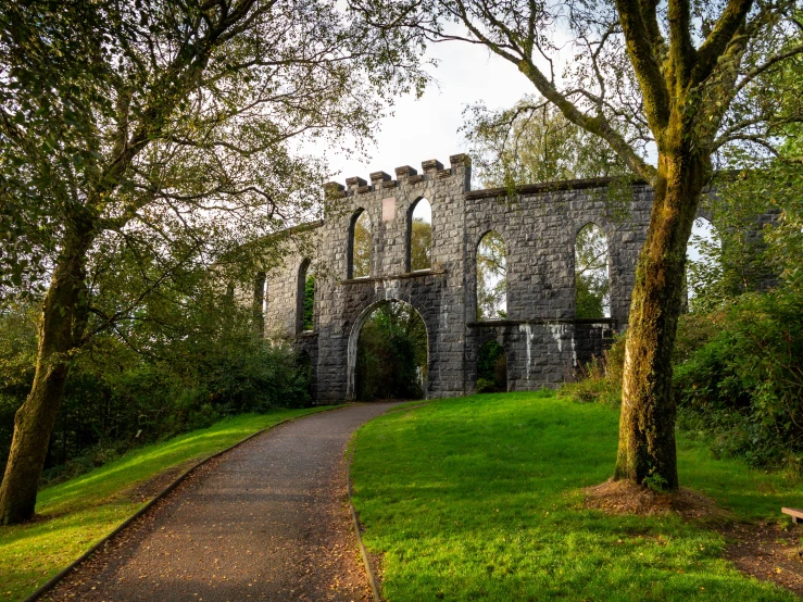 an old stone structure near a leafy tree