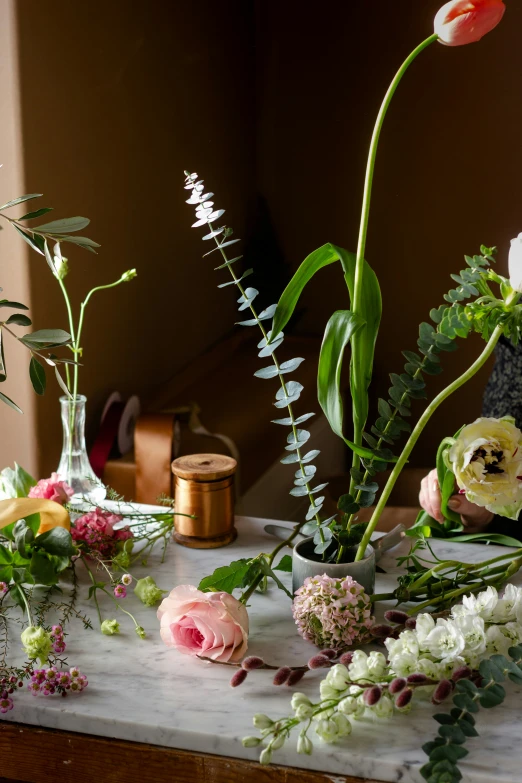 a collection of flowers and foliage on a table