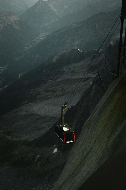 a dark picture of a tram coming down a mountain