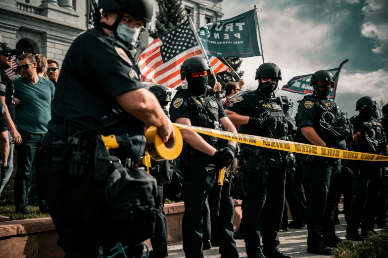 police standing next to each other with yellow and black batons