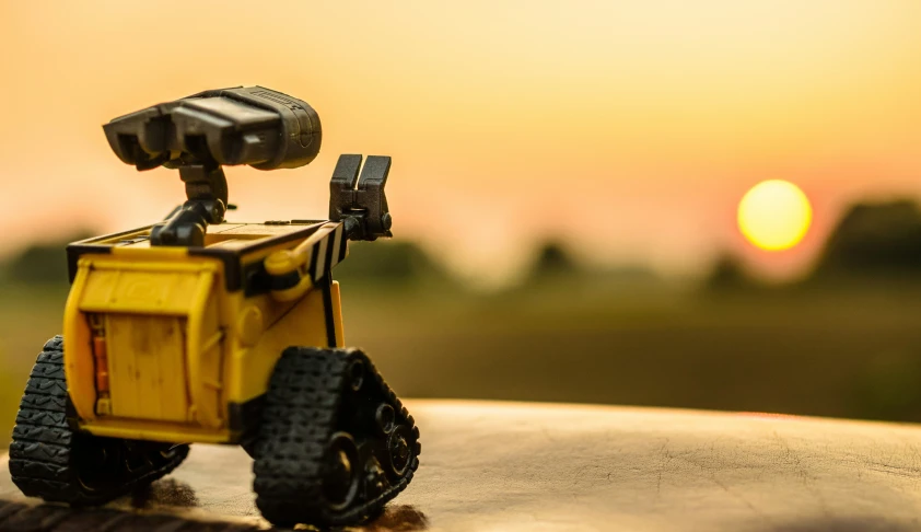 toy truck that is yellow sitting on top of a table