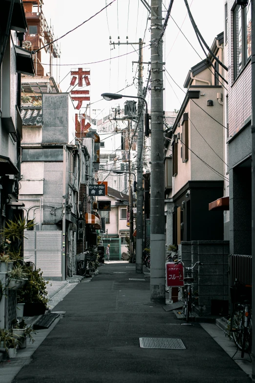 a black and white po of an alley with power lines overhead