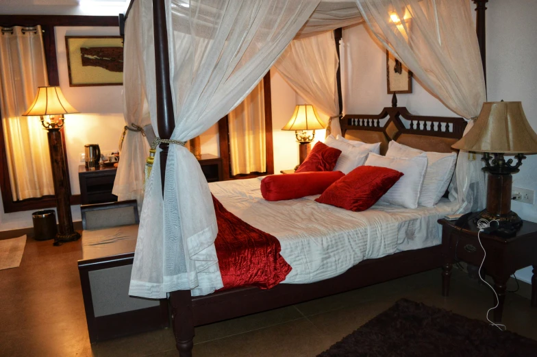 a large white bed with four pillows and a canopy