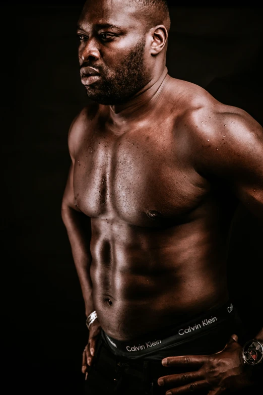 a man with  on standing against a black background