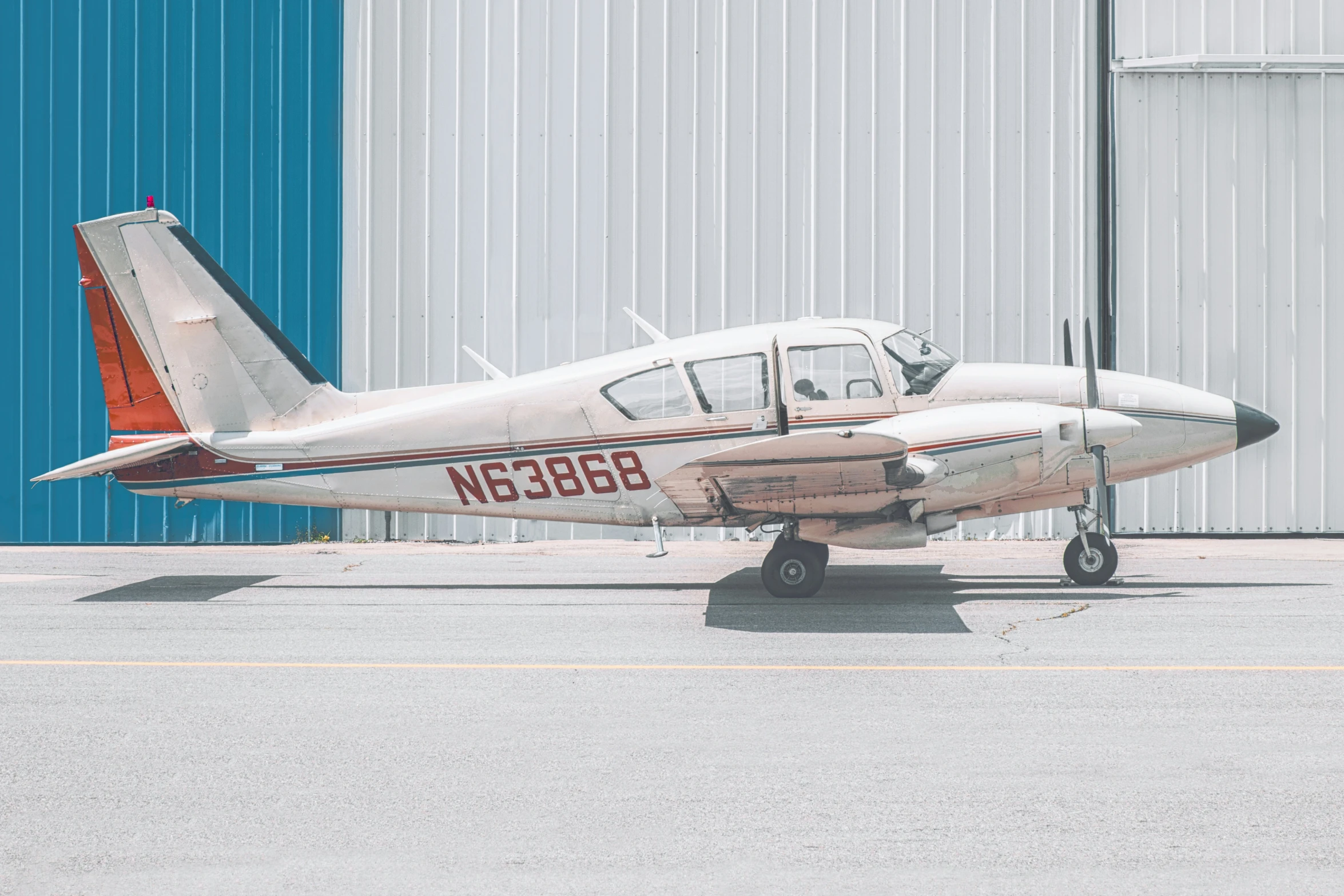 a single engine plane parked in front of a hangar