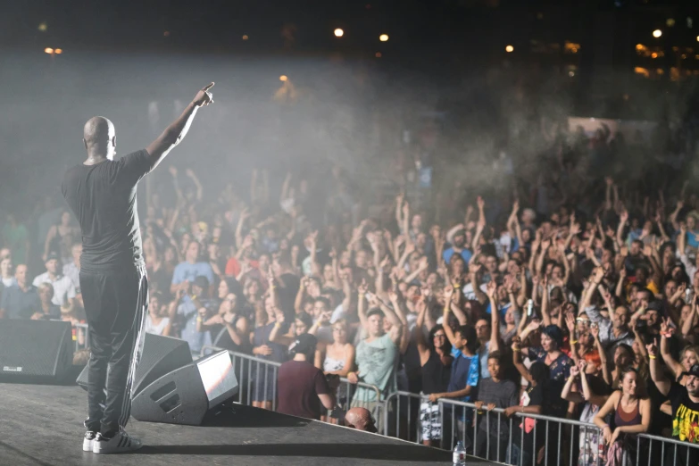 a man standing on stage holding his hands up