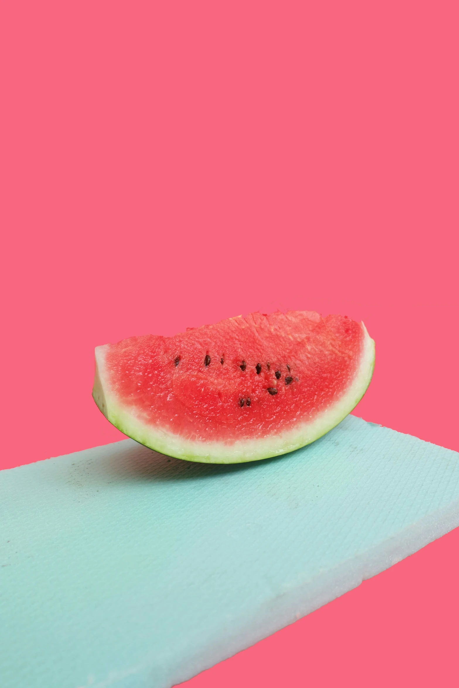 a slice of watermelon on a blue piece of cloth