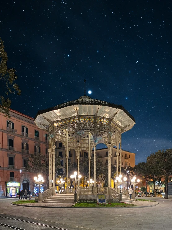 a well lit area with stairs and tables in the foreground