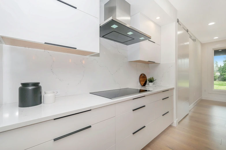 a clean white kitchen has a view of the garden