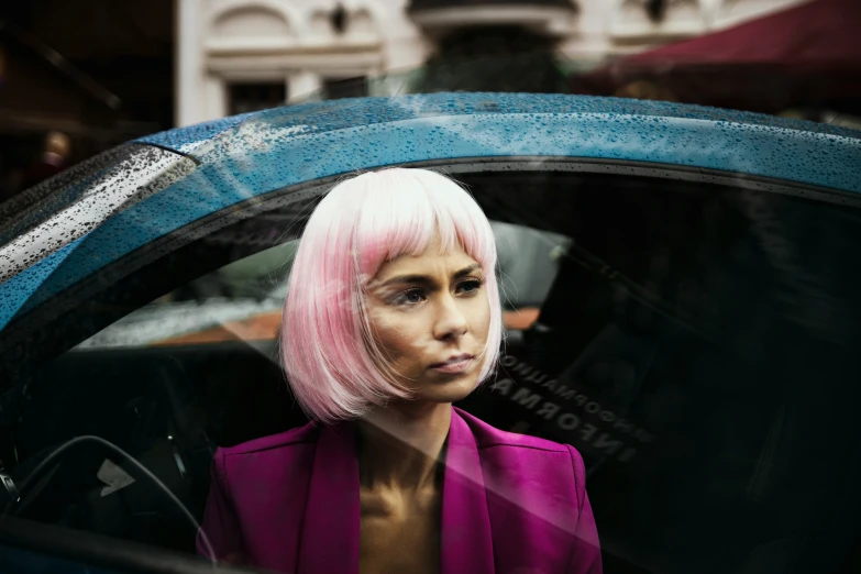 a women with pink hair sitting in a car