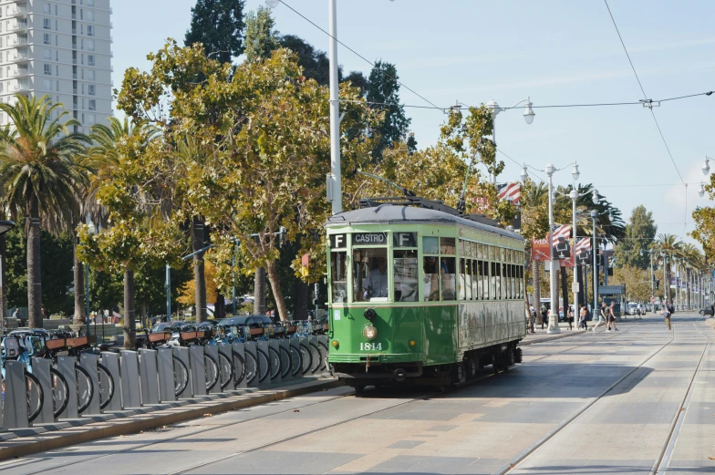 a trolley going down the tracks near several trees