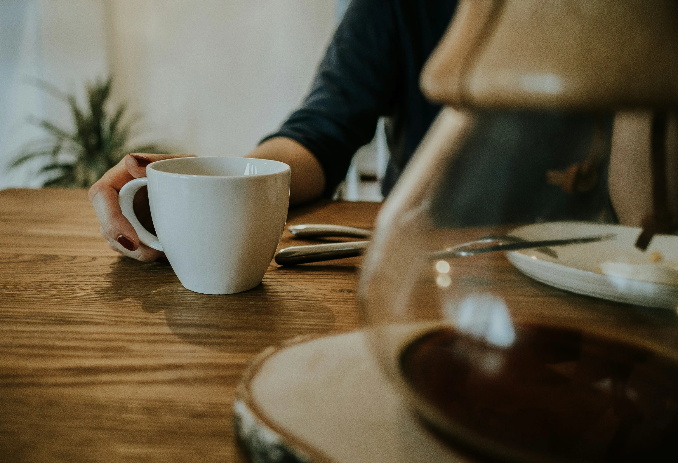 there is a white cup on a wooden table