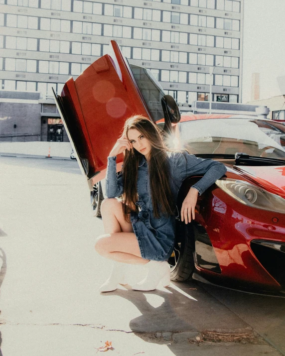 a woman is kneeling on the side of a car