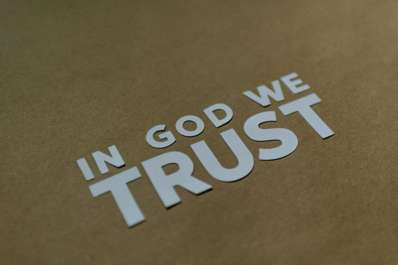 the word in god we trust is painted on a brown background