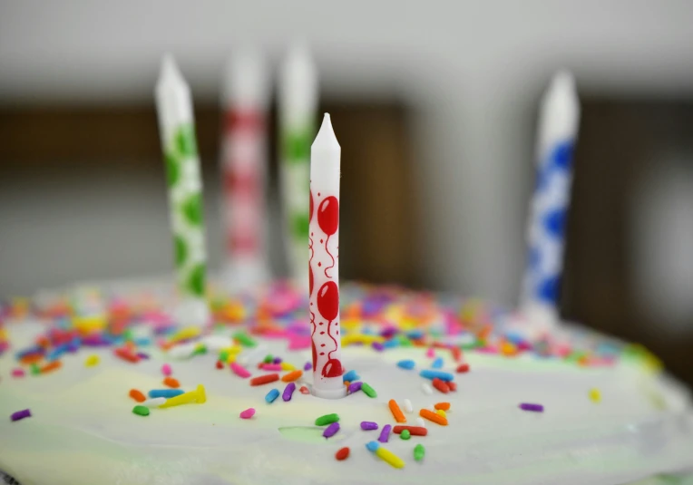 a frosted cake with lit candles sitting on top of it