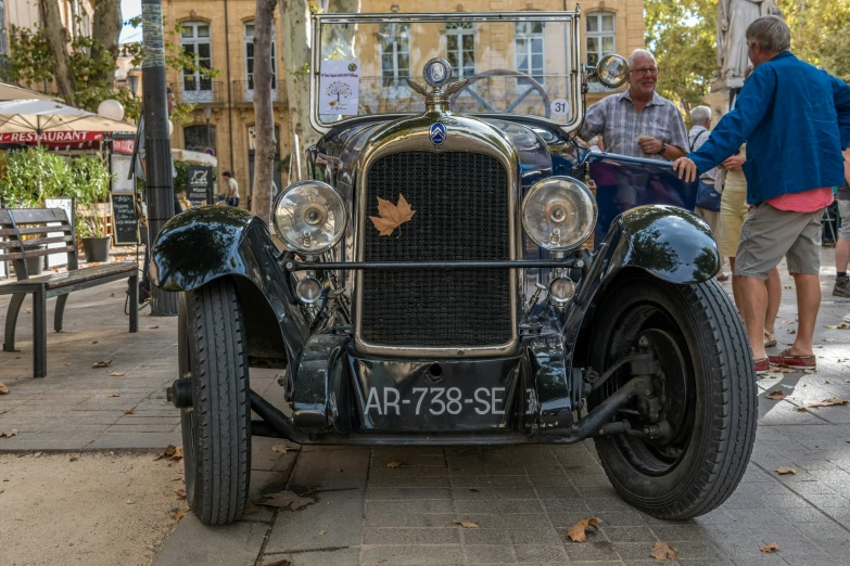 an old fashion car parked on the side of a street