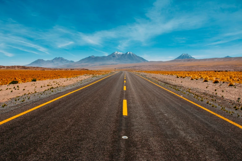 a lonely road stretches across the desert into the mountains