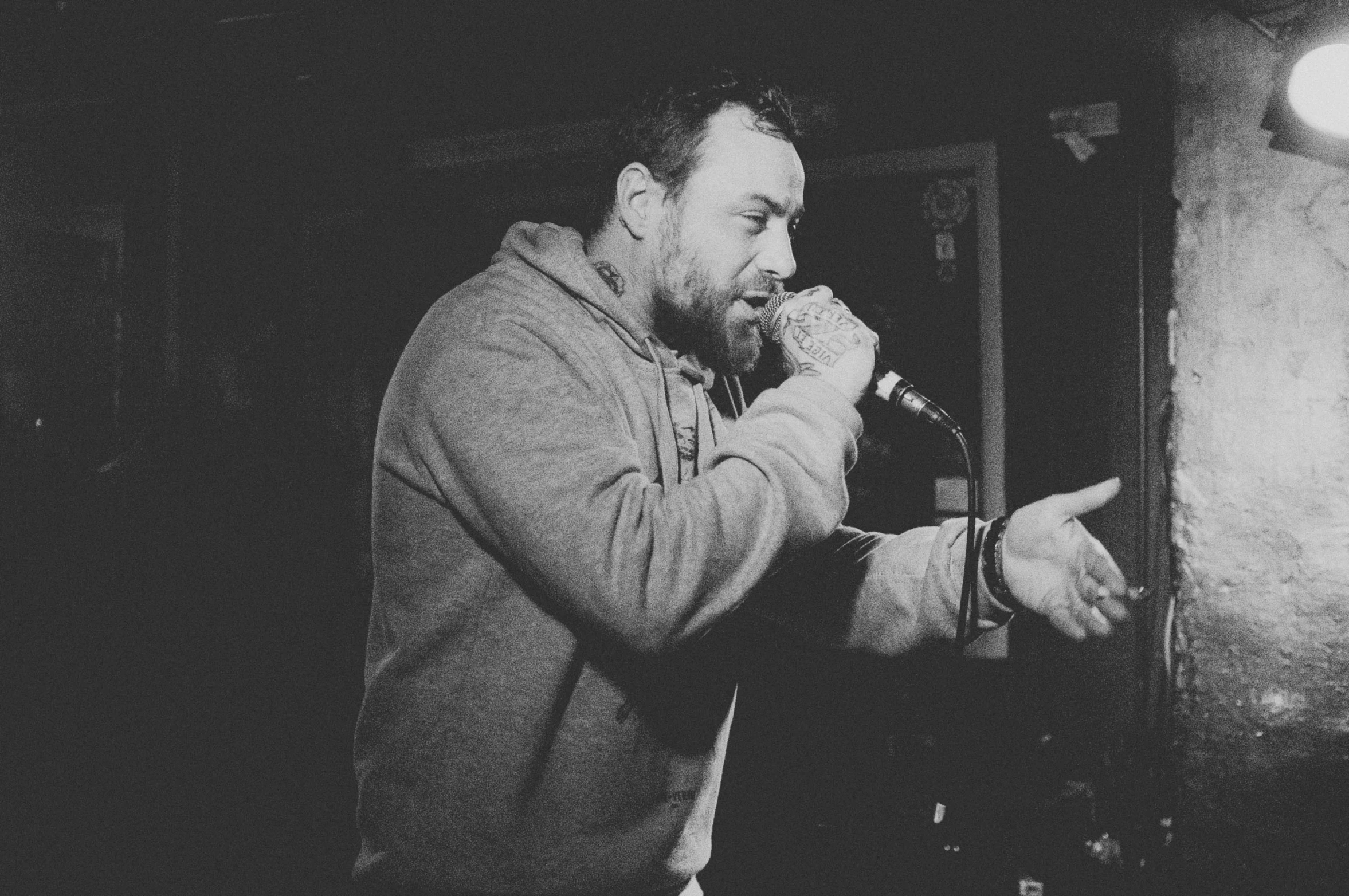 a man standing on a stage with his hands clasped together