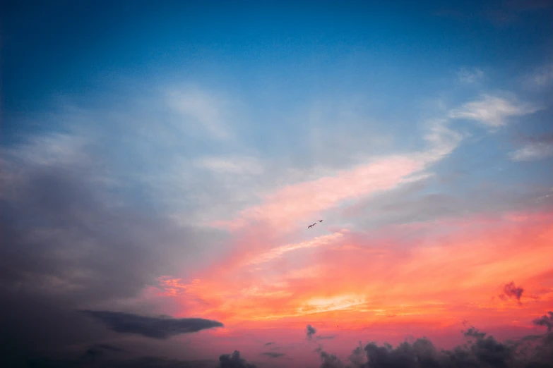 a plane is flying in front of a beautiful sunset