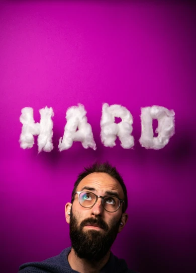 a man with a beard and eye glasses has the word hard written on it