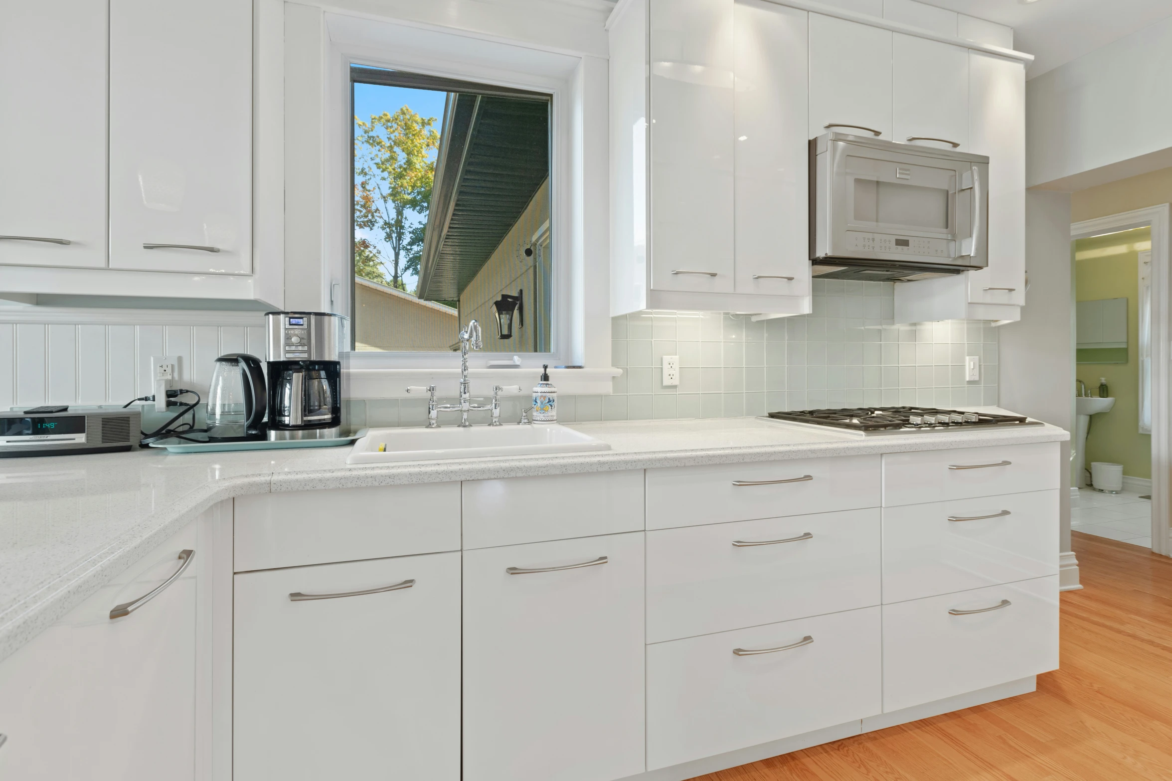 a clean kitchen with white cabinets and a breakfast bar