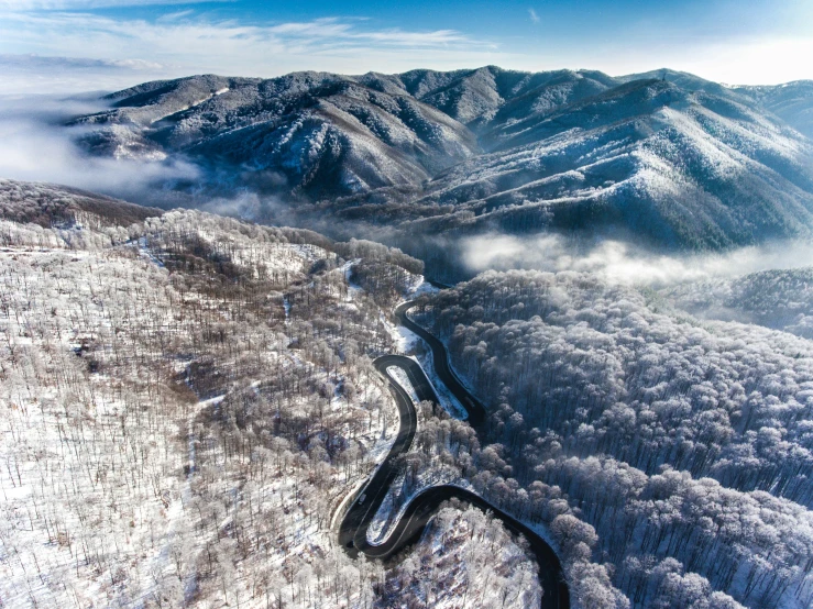 the road is near some mountains and snow