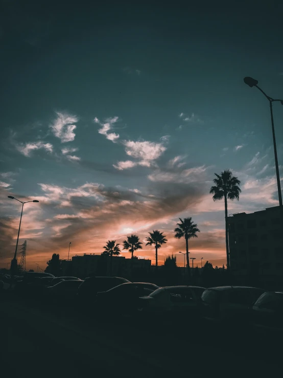 the sun is rising over some parked cars