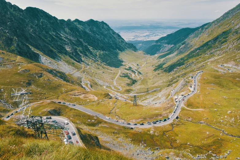 an aerial view of a winding road near mountains