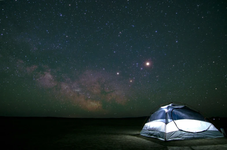 a tent pitched up against a dark night sky